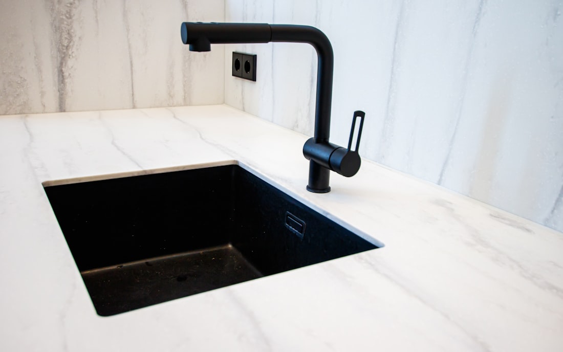 Installed marble countertop with black undermount sink after final cleanup and seal